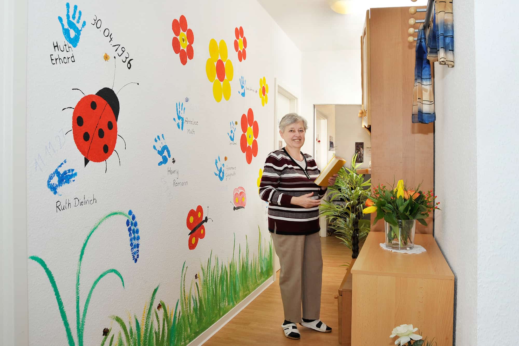 Frau in Flur mit bunten Wandmalereien